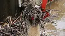 Sebuah eskavator mengangkat tumpukan sampah di Pintu Air Manggarai Jakarta, Senin (12/11). Hujan deras yang mengguyur pada Minggu malam membuat sampah yang terbawa arus Kali Ciliwung menutupi Pintu Air Manggarai. (Liputan6.com/Fery Pradolo)