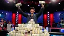 Qui Nguyen asal Amerika menunjukan uang usai memenangkakn Kompetisi Poker Dunia di Las Vegas, AS (2/11). Nguyen berhasil memenangkan hadiah sepesar 8 juta dollar AS. (AP/John Locher)