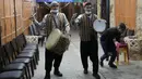 Pria Palestina yang dikenal dengan "Musaharatis" saat bertugas sebagai "penabuh drum Ramadhan" di kota tua Hebron, Tepi Barat pada 14 April 2021. Mereka menyusuri jalan-jalan kota, masuk ke gang-gang kecil untuk membangunkan umat Islam sahur selama bulan Ramadhan. (HAZEM BADER/AFP)