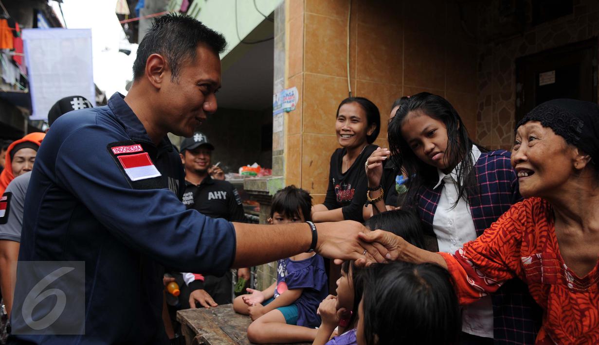 Cagub DKI Jakarta, Agus Harimurti Yudhoyono  menyalami warga saat blusukan di kawasan Kampung Pulo, Jakarta, Selasa (27/12). Dalam Kampanyenya AHY berjanji untuk mengurangi jumlah pengangguran dan penciptaan lapangan kerja. (Liputan6.com/Gempur M Surya)