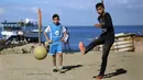 Seorang anak menendang bola saat bermain di kawasan Gaza, Jumat (3/11/2017). Sepak bola tidak hanya menjadi olahraga favorit, tapi juga sebagai salah satu cara bagi warga untuk mengurangi ketegangan akibat peperangan. (AFP/Mohammed Abed)