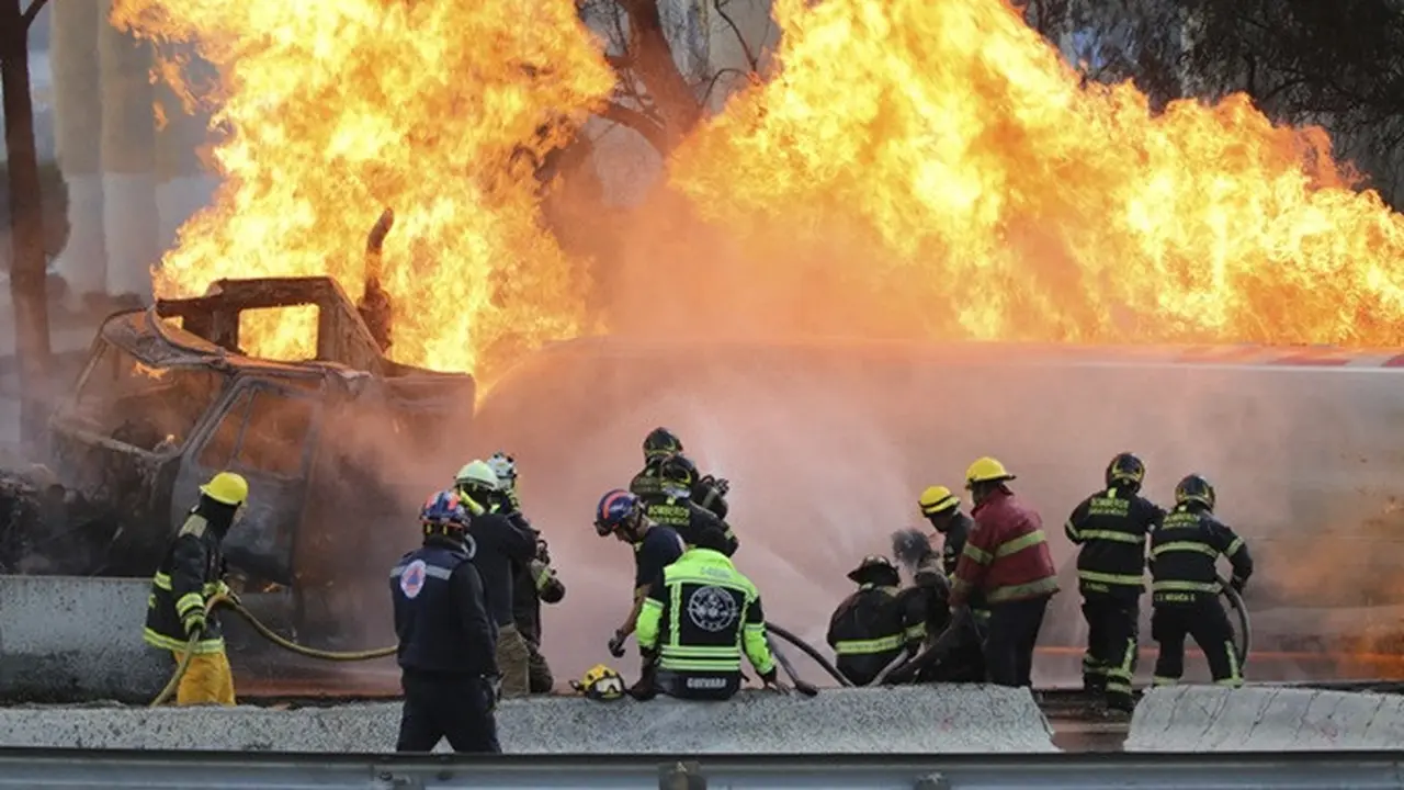 Petugas pemadam kebakaran menyemprotkan air ke sebuah truk tangki gas yang meledak di bawah jembatan layang jalan tol di Mexico City, Meksiko, Rabu (10/9/2025).