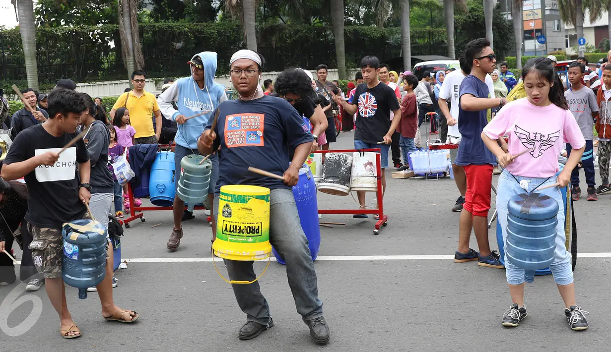 Penampilan dari Kreasi Musik Mahasiswa IISIP yang memainkan alat musik dari barang bekas di kawasan Bundaran HI, Jakarta, Minggu (14/5). Pertunjukkan musik tersebut bertujuan untuk mengalang dana. (Liputan6.com/Immanuel Antonius)