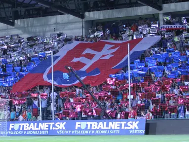  Suporter Slowakia membentangkan bendera nasionalnya di tribun selatan Stadion MSK Zilina. (Bola.com/Reza Khomaini)