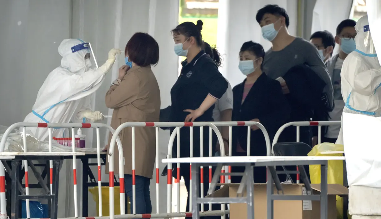 <p>Seorang pekerja mengenakan baju pelindung mengambil swab untuk tes COVID-19 di fasilitas pengujian virus corona di Beijing, China, Sabtu (23/4/2022). Beijing dalam keadaan waspada setelah 10 siswa sekolah menengah dinyatakan positif COVID-19 pada hari Jumat, yang menurut pejabat kota sebagai putaran awal pengujian. (AP Photo/Mark Schiefelbein)</p>