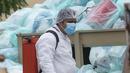 Petugas medis mengenakan alat pelindung diri saat mendisinfeksi limbah biologis berbahaya di luar Rumah Sakit del Instituto Mexicano del Seguro Social, Veracruz, Meksiko, Rabu (12/8/2020). Pembuangan limbah medis yang tidak tepat menjadi masalah di tengah pandemi COVID-19. (AP Photo/Felix Marquez)