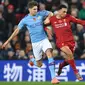 Bek Liverpool, Trent Alexander-Arnold berebut bola dengan bek Manchester City, John Stones dalam pertandingan pekan ke-12 Liga Inggris 2019-2020 di Anfield, Minggu (10/11/2019). Liverpool menghabisi Man City dengan skor cukup telak 3-1. (Paul ELLIS / AFP)