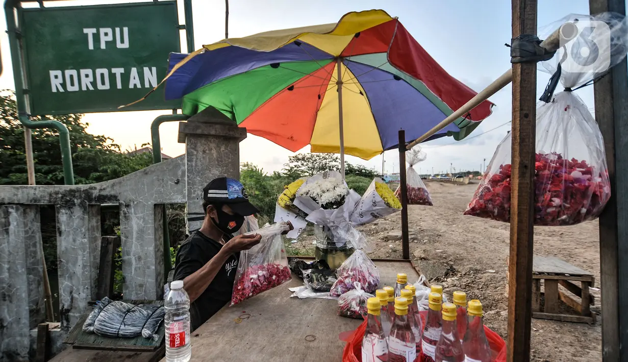 Pedagang merapikan bunga di TPU Rorotan, Jakarta, Selasa (10/8/2021). Adanya TPU Rorotan yang dikhususkan untuk pemakaman jenazah pasien Covid-19 membawa rezeki baru bagi warga setempat, yakni berjualan bunga bagi peziarah. (merdeka.com/Iqbal S. Nugroho)
