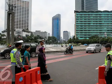 Petugas menutup jalan yang mengarah ke Sarinah, Jakarta, Kamis (14/1/2016). Paska teror bom dan penembakan di Sarinah, ruas jalan thamrin lengang. (Liputan6.com/Faizal Fanani)