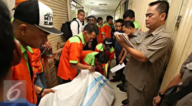 Pedagang dibantu petugas mengemasi barang dagangannya saat dilakukan pengosongan di Pasar Blok F Tanah Abang, Jakarta, Rabu (4/5). Pengosongan dilakukan karena para pemilik kios menunggak pembayaran yang mereka pakai. (Liputan6.com/Immanuel Antonius)