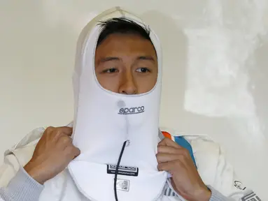 Ekspresi pebalap Manor Racing asal Indonesia, Rio Haryanto, saat memakai pengaman api jelang latihan bebas ketiga F1 GP Australia di Sirkuit Albert Park, Australia, Sabtu (19/3/2016). (Reuters/Brandon Malone)