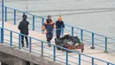 Petugas Kementerian Pertahanan Rusia mendorong gerobak dengan membawa kantong plastik di dermaga Laut Hitam di pinggiran Sochi, Rusia (25/12). Mereka menuju Suriah untuk ikut serta dalam penampilan tahun baru bagi tentara Rusia. (REUTERS/Yevgeny Reutov) 