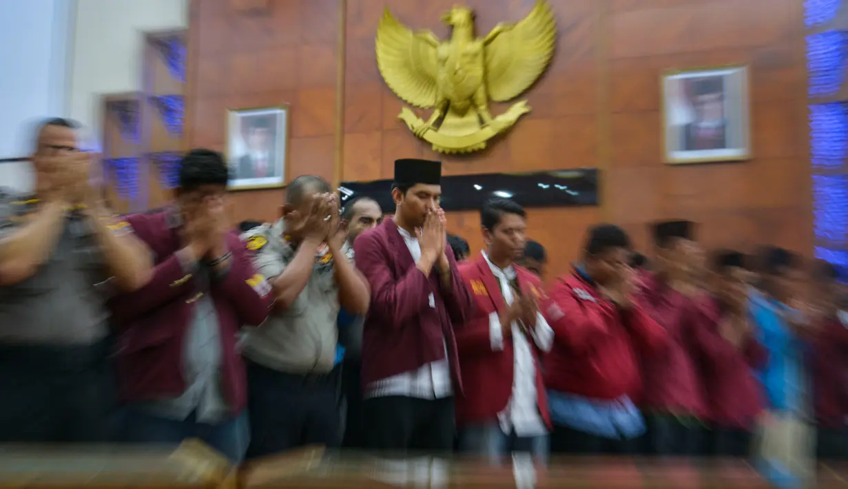 Salat gaib dan doa bersama mahasiswa dari berbagai perguruan tinggi dan anggota kepolisian di Gedung Dewan Perwakilan Rakyat Aceh (DPRA), Jumat (27/9/2019). Doa dan salat gaib itu untuk 2 mahasiswa Universitas Halu Oleo Kendari yang tewas saat demo, Randi dan Yusuf. (CHAIDEER MAHYUDDIN/AFP)