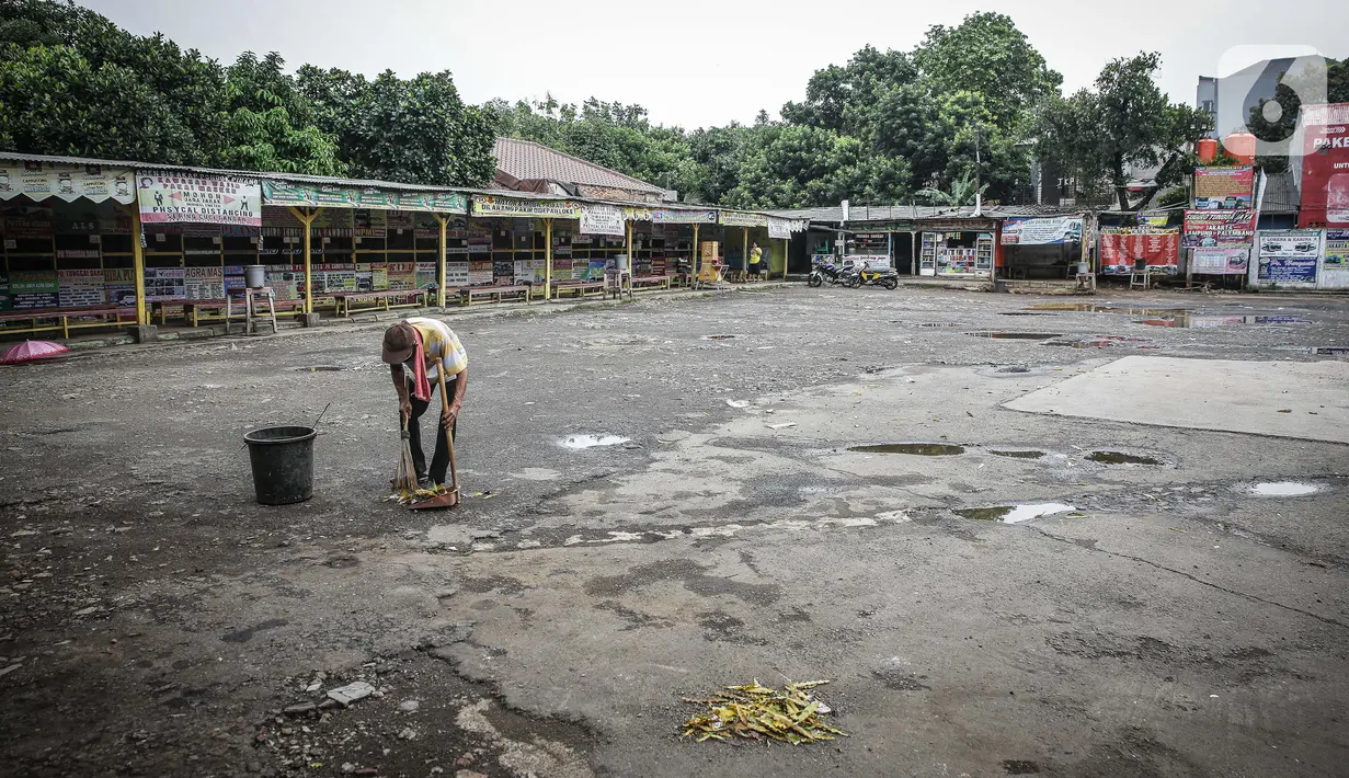 Seorang pria terlihat membersihkan area terminal Pondok Pinang, Jakarta, yang tampak tutup dan sepi pada Kamis (6/5/2021). Pelayanan terminal Pondok Pinang mati suri seiring telah diberlakukan larangan mudik Lebaran mulai hari ini, 6 hingga 17 Mei 2021. (Liputan6.com/Faizal Fanani)