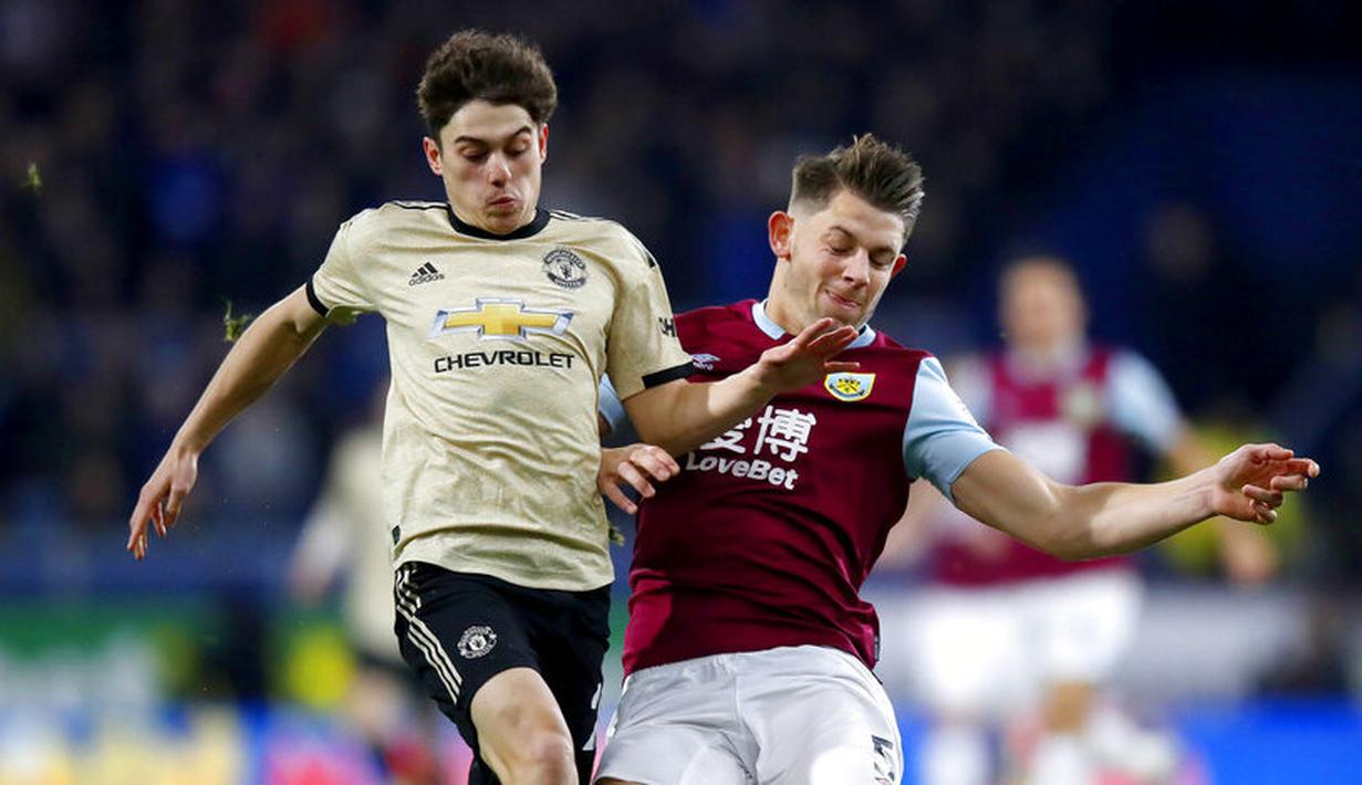 Gelandang Manchester United, Daniel James, berebut bola dengan pemain Burnley, James Tarkowski, pada laga Premier League di Stadion Turf Moor, Sabtu (28/12). Burnley takluk 0-2 dari Manchester United. (AP/Martin Rickett)
