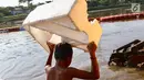 Seorang anak membawa styrofoam untuk berenang di Kanal Banjir Barat, Jakarta, Jumat (23/3). Anak-anak nekat berenang di lokasi ini meski berbahaya bagi kesehatan dan keselamatan. (Liputan6.com/Immanuel Antonius)
