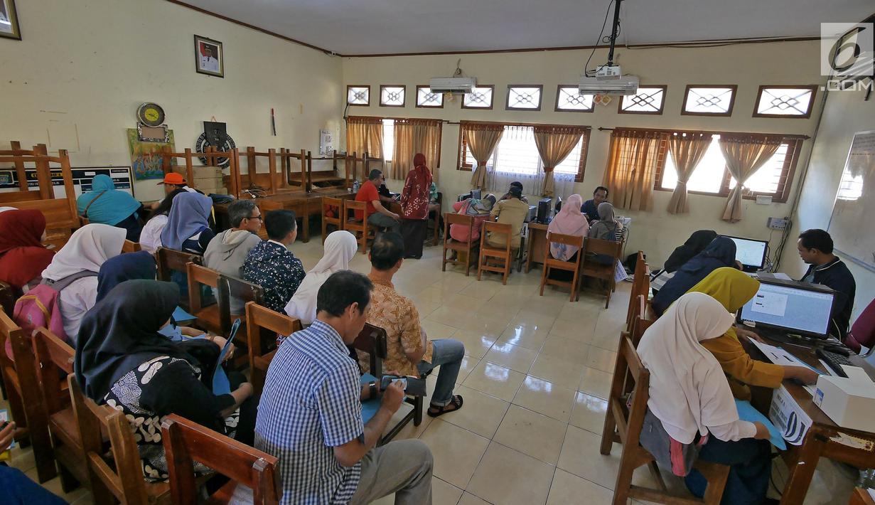 Suasana saat orangtua murid saat mengisi kelengkapan seleksi Penerimaan Peserta Didik Baru (PPDB) di SMAN 1 Depok,  Kota Depok, Jawa Barat, Selasa (18/6/2019). Sistem PPDB Jawa Barat berlangsung pada tanggal 17-22 Juni 2019. (Liputan6.com/Herman Zakharia)