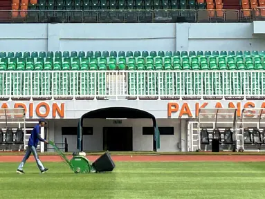 Seorang petugas melakukan perawatan rumput Stadion Pakansari, Cibinong, Kabupaten Bogor, Rabu (23/7/2026). Perawatan lapangan terus dilakukan menjelang Stadion Pakansari menjadi kandang Timnas Indonesia pada babak penyisihan Grup A Piala AFF 2026. Pengelola stadion melakukan treatment rumput sejak berakhirnya Pegadaian Championship 2025/2026 dengan pendampingan dari tim PSSI agar kondisi lapangan memenuhi standar untuk pertandingan internasional. (Bola.com/Muhammad Adi Yaksa)