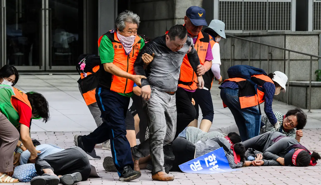 Pegawai kantor distrik mengenakan rompi visibilitas tinggi saat mereka membantu menolong korban selama simulasi latihan anti-teror, di Seoul, Korea Selatan pada tanggal 20 Agustus 2024. (ANTHONY WALLACE/AFP)