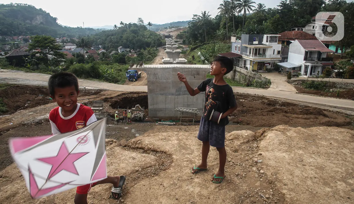 Anak-anak bermain di proyek pembangunan kereta cepat yang sedang dalam tahap pengerjaan di Padalarang, Kabupaten Bandung, Sabtu (25/9/2021). Kereta cepat Jakarta-Bandung ditargetkan beroperasi pada akhir tahun 2022 dan akan dilakukan uji coba pada November 2022 mendatang. (Liputan6.com/Johan Tallo)