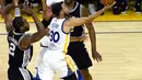 Pemain Warriors, Stephen Curry (30) berusaha memasukan bola dari kawalan LaMarcus Aldridge (12) saat bertanding pada gim pertama final Wilayah Barat playoffs NBA 2017 di Oakland, California (14/5). (Thearon W. Henderson/Getty Images/AFP)