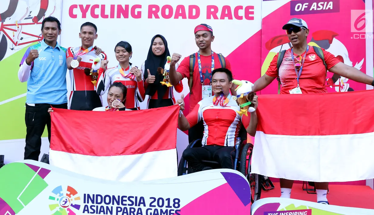 Atlet dan pelatih ParaCycling Indonesia berfoto bersama usai pengalungan medali ITT Road Race Asian Para Games 2018 di Sirkuit Sentul, Bogor, Senin (8/10). Indonesia berhasil merebut 3 perak dan 4 perunggu ITT Road Race. (Liputan6.com/Helmi Fithriansyah)