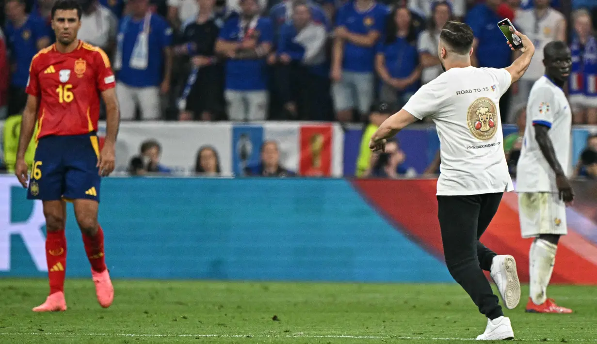 Semifinal Euro 2024 antara Spanyol dan Prancis dihentikan sementara ketika seorang penonton berlari ke lapangan selama pertandingan. (JAVIER SORIANO / AFP)