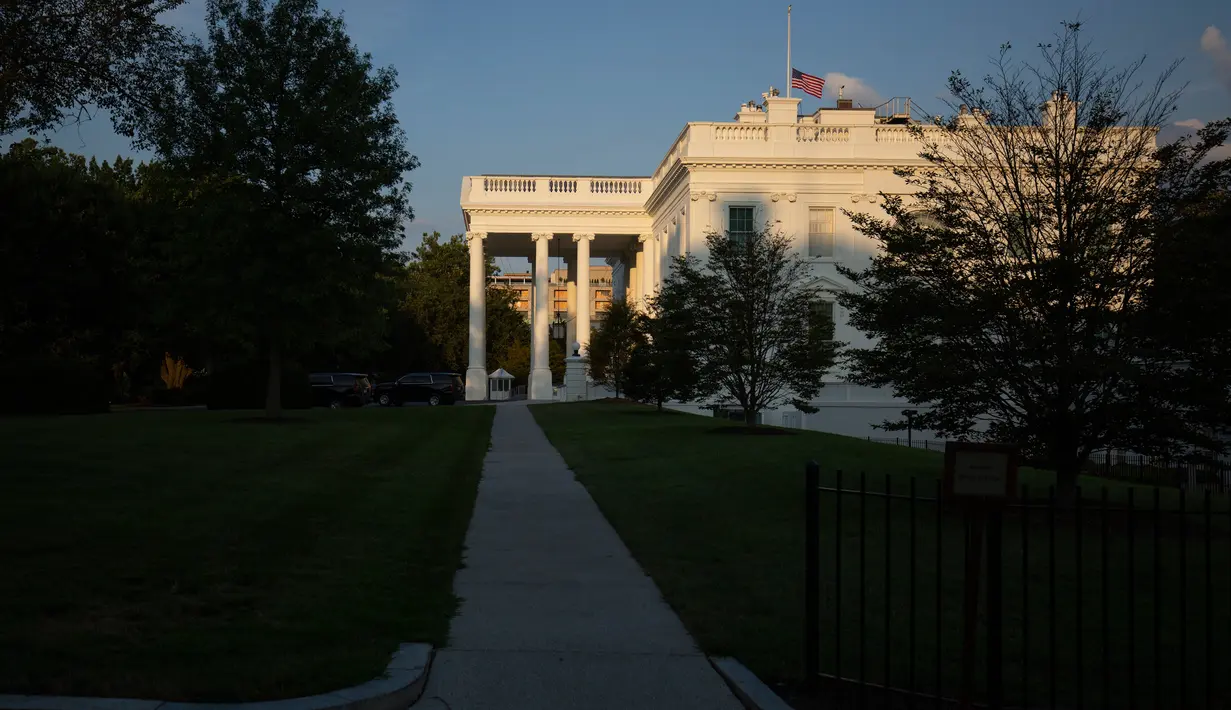 Pemandangan bendera nasional AS yang berkibar setengah tiang di Gedung Putih, Washington DC, Minggu (4/8/2019). Presiden Donald Trump memerintahkan bendera dikibarkan setengah tiang selama lima hari sebagai simbol dukacita atas dua penembakan massal di El Paso, Texas, dan Ohio. (Alastair Pike/AFP)