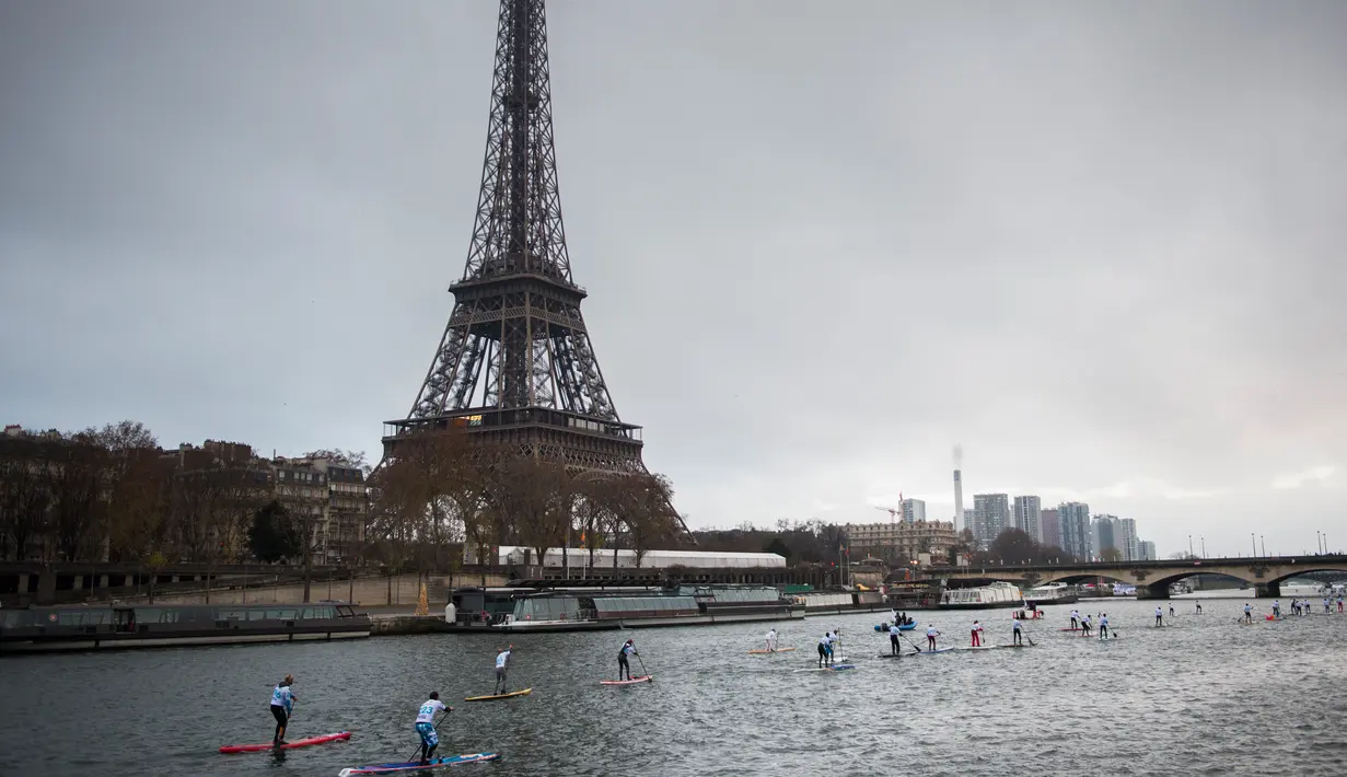 Peserta mendayung melewati aliran sunga- sungai selama perlombaan dayung dan perahu di Sungai Seine di Paris, Perancis, Minggu, (2/12). Peserta akan mendayung sejauh 10 km. (AFP)