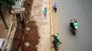 Warga melintas di sisi proyek pembangunan trotoar Jalan Raya Kalibata, Jakarta, Rabu (2/11). Pembangunan penataan trotoar di kawasan Jalan Raya Kalibata, Jakarta Selatan baru mencapai 15 persen. (Liputan6.com/Helmi Fithriansyah)