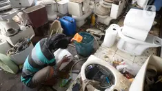 Penjual membersihkan kloset duduk bekas di Jalan Raya Ciater, Serpong, Tangerang Selatan, Banten, Jumat (13/11/2020). Kloset duduk bekas tersebut dikirim dari Jakarta dibersihkan serta diservis seperti baru. (merdeka.com/Dwi Narwoko)