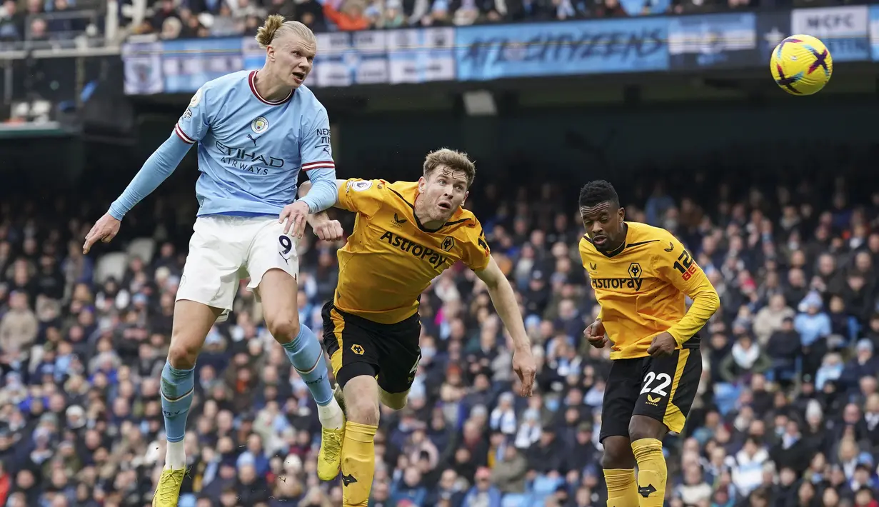Pemain Manchester City, Erling Haaland (kiri) mencetak gol pertama timnya ke gawang Wolves saat laga lanjutan Liga Inggris 2022/2023 melawan Wolves yang berlangsung di Etihad Stadium, Manchester, Minggu (22/01/2023) dini hari WIB. Hattrick Haaland ke gawang Wolves menjadi yang keempat di Liga Inggris. Catatan tersebut berhasil mengalahkan rekor milik Cristiano Ronaldo yang baru mencetak tiga hattrick. (AP Photo/Dave Thompson)