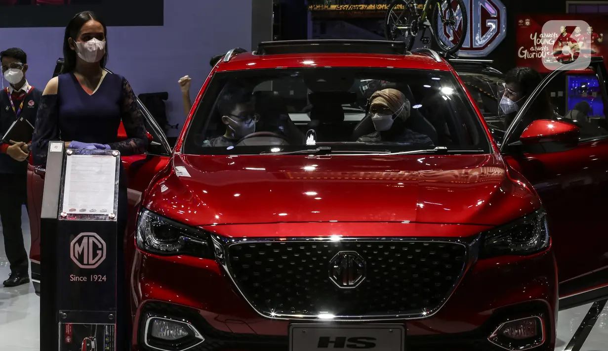 SPG berdiri dekat mobil yang dipamerkan di IIMS Hybrid 2021, JiExpo Kemayoran, Jakarta, Jumat (16/4/2021). Pemerintah memberi prioritas terhadap pengembangan industri otomotif agar bisa lebih berdaya saing global sesuai dengan sasaran pada peta jalan Making Indonesia 4.0. (Liputan6.com/Johan Tallo)