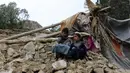 Duan anak laki-laki berada dekat rumah mereka yang rusak dalam gempa bumi di Distrik Spera, bagian barat daya Provinsi Khost, Afghanistan, 22 Juni 2022. Petugas PBB telah berusaha membantu situasi, namun upaya evakuasi terhambat oleh hujan deras. (AP Photo)
