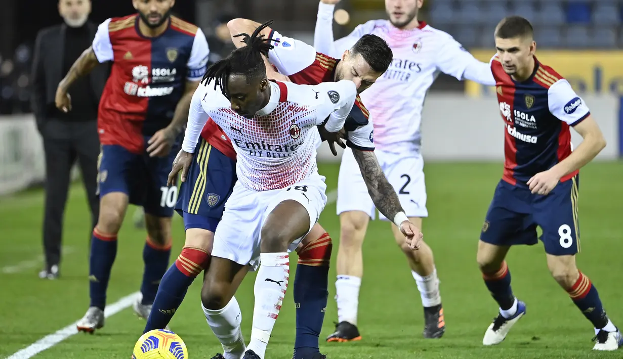 Gelandang AC Milan, Souhaliho Meite (depan) berebut bola dengan bek Cagliari, Luca Ceppitelli dalam laga lanjutan Liga Italia 2020/21 pekan ke-18 di Sardegna Arena, Senin (18/1/2021). AC Milan menang 2-0 atas Cgaliari. (AFP/Alberto Pizzoli)