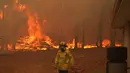 Seorang petugas pemadam kebakaran berada di lokasi kebakaran di dekat Wooroloo, di Perth, Australia, Selasa (2/1/2021). Kebakaran hutan tak terkendali di sebuah wilayah di sebelah timur laut Perth telah menghancurkan puluhan rumah dan kemungkinan mengancam lebih banyak lagi (Evan Collis/DFES via AP)