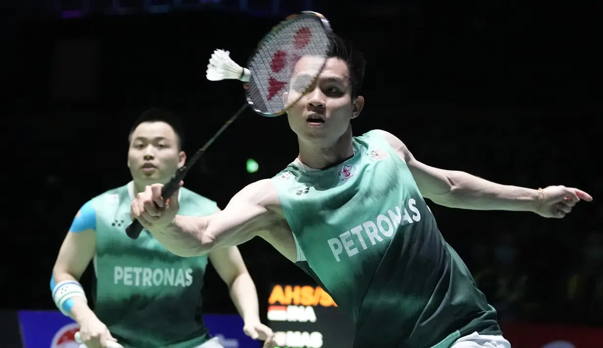 Keunggulan Mohammad Ahsan/Hendra Setiawan terus berlanjut hingga kedudukan 18-12. Aaron Chia/Soh Wooi Yik lantas bangkit dengan merebut 4 angka beruntun hingga akhirnya mampu menyamakan skor 19-19. Dua poin terakhir menjadi milik pasangan Malaysia yang akhirnya menang 21-19 di game pertama. (AP/Shuji Kajiyama)