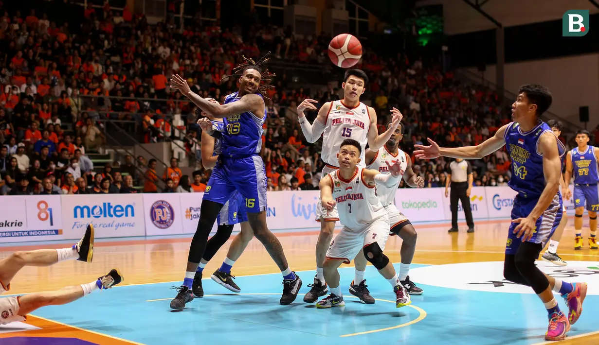 Pebasket Pelita Jaya, Andakara Prastawa Dhyaksa (tengah bawah) dan Vincent Rivaldi Kosasih berusaha merebut bola dari pebasket Prawira Bandung pada laga gim pertama final IBL 2023 di Hall Senayan, Jakarta, Kamis (20/07/2023). Laga dimenangkan oleh Prawira Bandung dengan skor 74-65. (Bola.com/Bagaskara Lazuardi)