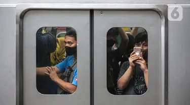 Penumpang berada di dalam rangkaian KRL di Stasiun KRL Commuter Line Sudirman, Jakarta, Jumat (30/12/2022). Menteri Perhubungan (Menhub) Budi Karya Sumadi memastikan bahwa tarif KRL Commuter Line tidak akan mengalami kenaikan pada 2023 mendatang. Namun, skema pembayarannya akan dipisah antara penumpang yang mampu dan kurang mampu melalui tiket kartu. (Liputan6.com/Faizal Fanani)