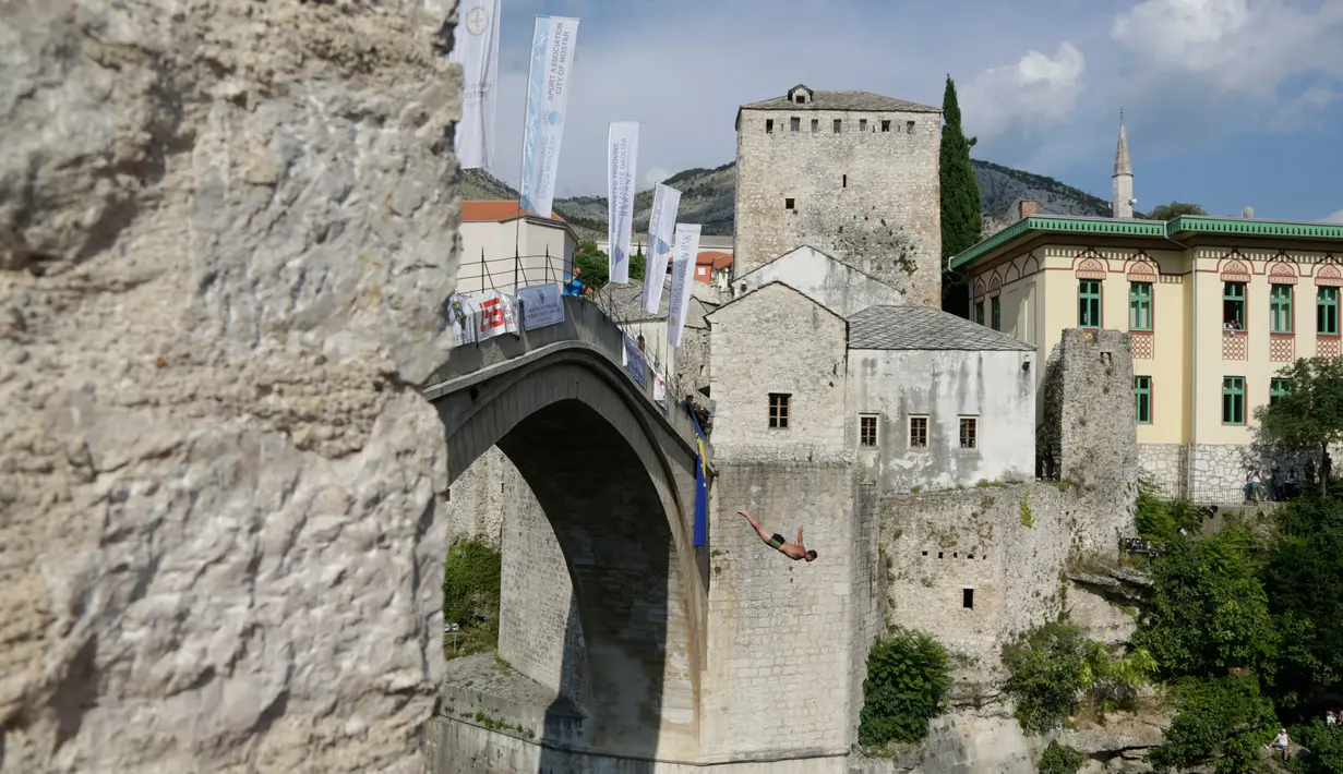 Peserta melompat dari Jembatan Old Mostar pada kompetisi menyelam tradisional ke-452 di Mostar, Bosnia, 29 Juli 2018. Sebanyak 40 penyelam dari Bosnia dan negara tetangga harus melompat dari jembatan setinggi 24 meter ke Sungai Neretva. (AP/Amel Emric)