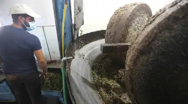 Seorang staf bekerja di sebuah pabrik pengolahan minyak zaitun di Borj Qalaouiye, Lebanon selatan, pada 18 Oktober 2020. Beberapa wilayah di Lebanon selatan masih menggunakan cara-cara tradisional untuk mengekstraksi minyak dari buah zaitun. (Xinhua/Bilal Jawich)