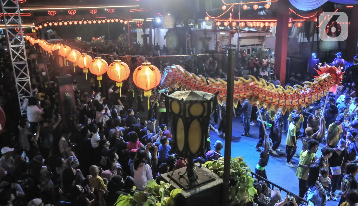 Warga menyaksikan pawai Liong dan Barongsai saat perayaan Cap Go Meh di Jalan Surya Kencana, Bogor, Jawa Barat, Minggu (5/2/2023). Pemkot Bogor kembali menggelar perayaan Cap Go Meh setelah 3 tahun ditiadakan akibat pandemi Covid-19. (merdeka.com/Iqbal S Nugroho)