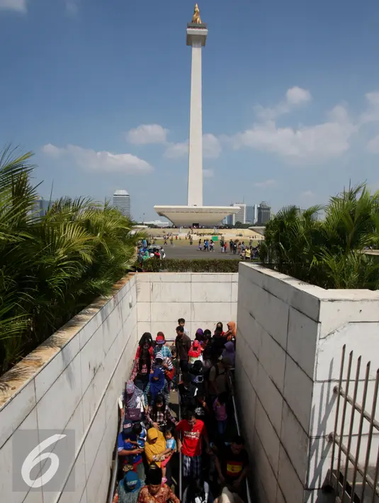 Antrean panjang ratusan pengunjung Monumen Nasional atau Monas, Jakarta, Minggu (19/7/2015). Ikon kota Jakarta tersebut menjadi tempat wisata alternatif warga saat liburan lebaran. (Liputan6.com/Johan Tallo)