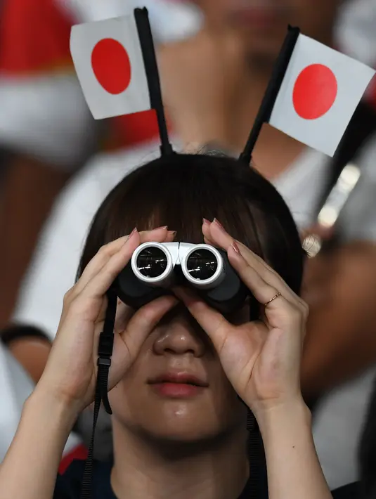 Fans wanita menggunakan teropong menunggu pertandingan antara Rusia dan Jepang pada pembukaan Rugby World Cup Pool A  di Stadion Tokyo (20/9/201). Rugby World Cup diselenggarakan dari 20 September hingga 2 November 2019. (AFP Photo/Toshifumi Kitamura)