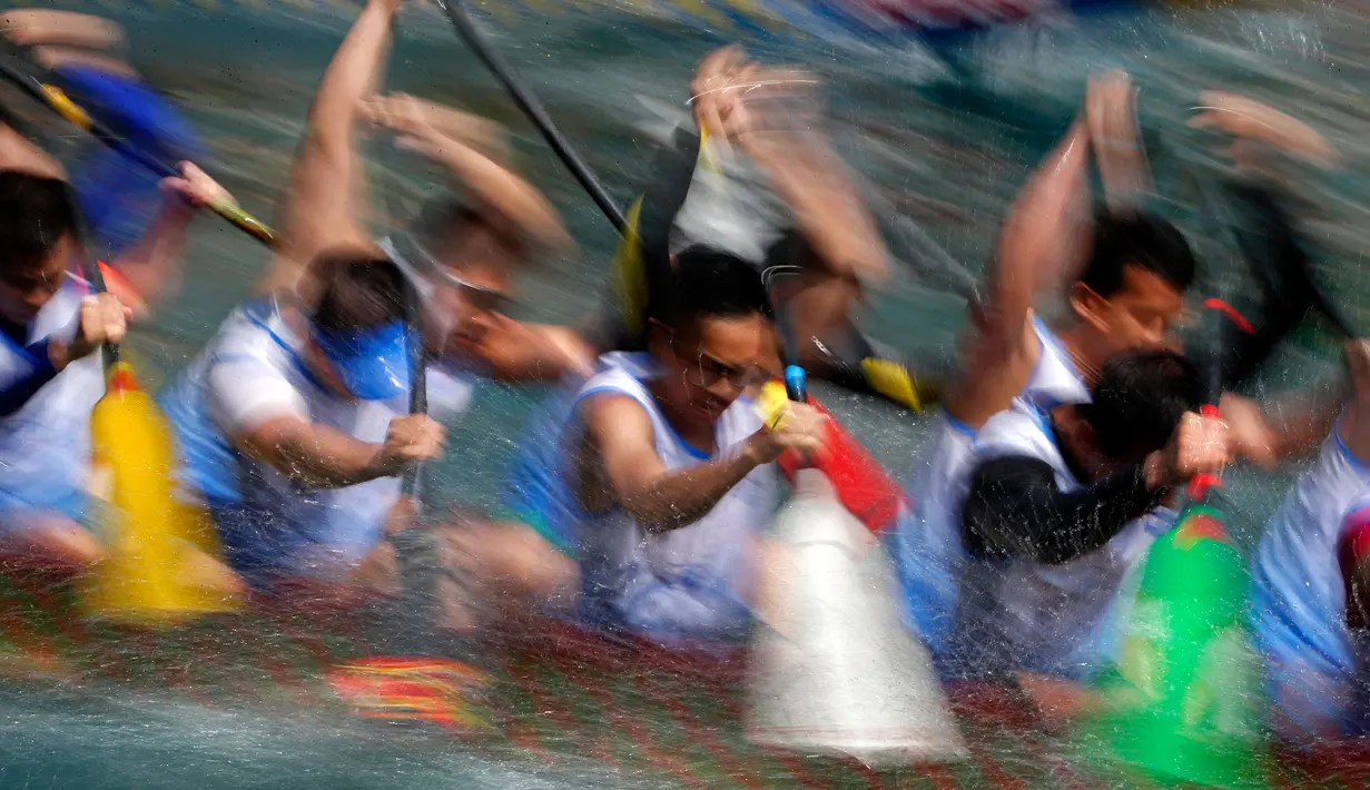 Peserta saat mengayuh perahu dalam lomba perahu naga di Hong Kong, Selasa, (30/5). Turnamen ini diselenggarakan untuk memperingati festival perahu naga yang diadakan di seluruh Hong Kong. (AP Photo / Vincent Yu)