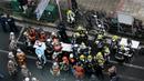 Petugas pemadam kebakaran bekerja di depan sebuah gedung, tempat kebakaran terjadi di Osaka (17/12/2021). Polisi masih menyelidiki penyebab kebakaran lantai empat di bangunan berlantai delapan tersebut. (AFP/STR/Jiji Pers)