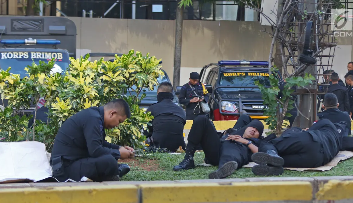 Sejumlah Korps Brimob beristirahat disela penjagaan mereka di kawasan MH Thamrin, Jakarta, Jumat (24/5/2019). Usai kerusuhan 22 Mei 2019, penjagaan di kawasan jalan MH Thamrin sampai Jumat, 24 Mei 2019 masih terus dilakukan oleh aparat kepolisian. (Liputan6.com/Herman Zakharia)