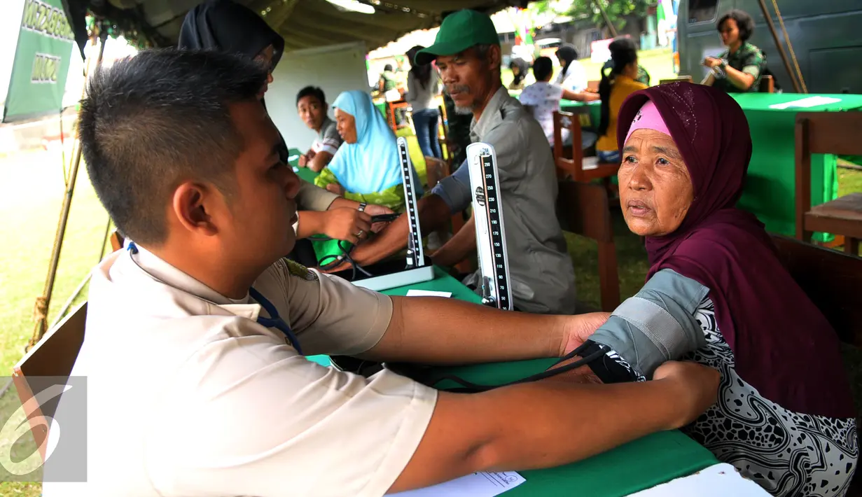 Petugas memeriksa warga dalam rangka Hari Juang Kartika ke-70 dan HUT ke-66 Kodam Jaya di Teluknaga, Tangerang, Selasa (22/12). Korem 052 Wijayakrama melaksanakan bakti sosial berupa pembagian sembako sebanyak 2.000 paket. (Liputan6.com/Faisal R Syam)