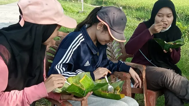 Dhira (20) menikmati sega ndoreng di pinggir sawah Desa Kendaldoyong Kecamatan Wonosalam Demak. Selasa,1/6/2021. (Foto: Liputan6.com/Kusfitria Marstyasih)