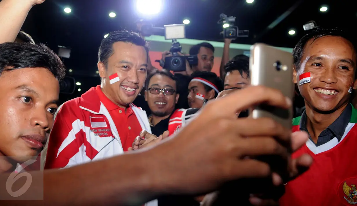 Seorang pendukung berselfie dengan Menpora Imam Nahrawi saat menyaksikan nobar Final Piala AFF 2016 antara Indonesia melawan Thailand di Kemenpora, Jakarta, (17/12). (Liputan6.com/Gempur M Surya)